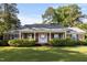 Charming brick home featuring a covered front porch with white columns and mature landscaping at 411 W Killiegrey St, Lillington, NC 27546
