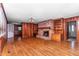 Spacious living room with hardwood floors, brick fireplace, built-in shelving, and wood paneling at 411 W Killiegrey St, Lillington, NC 27546