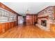 Bright living room featuring a brick fireplace and hardwood floors at 411 W Killiegrey St, Lillington, NC 27546
