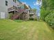 Expansive backyard featuring lush green lawn, mature trees, and elevated decks with stairs at 4125 Enfield Ridge Dr, Cary, NC 27519