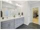 Bathroom featuring double sinks, gray cabinetry, and a large mirror at 4125 Enfield Ridge Dr, Cary, NC 27519