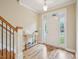 Bright entryway features hardwood floors and a staircase with wooden railing at 4125 Enfield Ridge Dr, Cary, NC 27519