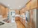 Well-lit kitchen features wooden cabinets, stainless steel appliances, gas range, and hardwood floors at 4125 Enfield Ridge Dr, Cary, NC 27519