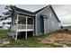 Angled view of new home's back exterior featuring a screened-in porch and concrete patio at 4167 Old Stage N Rd # 4, Angier, NC 27501