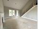 Living room with fireplace, tall ceilings, large windows and door, and stairs at 4167 Old Stage N Rd # 4, Angier, NC 27501