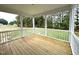 Relaxing outdoor porch featuring wood flooring and railing with views of mature trees at 4167 Old Stage N Rd # 4, Angier, NC 27501