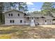 Rear view of the home showcasing gray siding, white trim, a well-manicured lawn, and multiple access points at 4307 Pope Rd, Durham, NC 27707