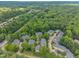 Wide aerial shot of the community with tree-lined streets and surrounding wooded areas, located near a road at 4802 Glenmist Ct, Raleigh, NC 27612