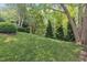 Beautiful backyard featuring well-maintained landscaping, lush green grass, and mature trees at 4802 Glenmist Ct, Raleigh, NC 27612