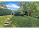 Tranquil backyard with lush greenery, a garden, and stone steps leading to a serene space at 4802 Glenmist Ct, Raleigh, NC 27612