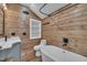 Rustic bathroom with wood paneled walls, modern fixtures, soaking tub, and granite vanity at 4802 Glenmist Ct, Raleigh, NC 27612