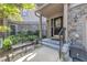 Cozy front porch featuring an iron bench, stylish black door with glass panels and stone accents at 4802 Glenmist Ct, Raleigh, NC 27612