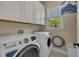 Functional laundry room featuring modern appliances, storage cabinets, and a window view at 4802 Glenmist Ct, Raleigh, NC 27612
