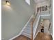 Staircase with carpet steps and wood railing leading to the lower level, with lots of natural light at 4802 Glenmist Ct, Raleigh, NC 27612