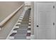 Carpeted staircase with white risers and wooden railing leading to an upper level at 4802 Glenmist Ct, Raleigh, NC 27612