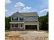 New two-story home featuring light gray siding, black shutters, and an attached two-car garage at 50 Moonraker Dr, Spring Hope, NC 27882