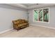 Basement room featuring neutral carpeting, a window to the backyard, and a cozy couch at 5314 Taproot Ln, Durham, NC 27705