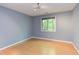 Bright bedroom with wood floors and a large window with peaceful nature views at 5314 Taproot Ln, Durham, NC 27705