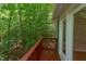 Spacious deck with red railings offers a beautiful view of the lush greenery at 5314 Taproot Ln, Durham, NC 27705