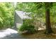 Side view of the gray home exterior with an attached garage and a paved driveway amid lush greenery at 5314 Taproot Ln, Durham, NC 27705