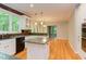 Open kitchen with granite counters and stainless appliances adjacent to sunroom at 5314 Taproot Ln, Durham, NC 27705