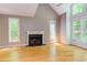 Bright living room featuring hardwood floors, fireplace, neutral walls, large windows, and vaulted ceilings at 5314 Taproot Ln, Durham, NC 27705