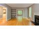 Bright living room with hardwood floors, fireplace, shelving, and view to sunroom with outdoor view at 5314 Taproot Ln, Durham, NC 27705