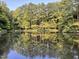 Reflections of the beautiful treeline on the calm waters of the community pond enhance the property's natural setting at 5314 Taproot Ln, Durham, NC 27705