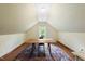 Finished attic space showcasing wood floors, neutral walls, and natural light from a window at 5513 Doemont Dr, Apex, NC 27539