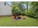 Inviting backyard with red Adirondack chairs circling a fire pit on a bed of gravel at 5513 Doemont Dr, Apex, NC 27539