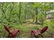 Secluded backyard seating area surrounded by lush greenery and a small creek at 5513 Doemont Dr, Apex, NC 27539