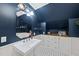 Bathroom showcasing a pedestal sink, wood-trimmed cabinets, and dark blue walls for a classic touch at 5513 Doemont Dr, Apex, NC 27539