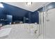 Elegant bathroom featuring navy walls, white wainscoting, and a modern glass shower, exuding style at 5513 Doemont Dr, Apex, NC 27539