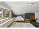 Bedroom featuring wood-look floors, blue accent wall, large window, and vaulted ceiling at 5513 Doemont Dr, Apex, NC 27539
