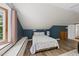 Attic bedroom featuring wood-look floors, blue accent wall, large window, and vaulted ceiling at 5513 Doemont Dr, Apex, NC 27539
