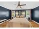 Comfortable bedroom featuring a ceiling fan, artwork, and large windows for natural light at 5513 Doemont Dr, Apex, NC 27539