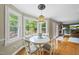 Cozy breakfast nook features large windows, hardwood floors, decorative light fixture and access to back deck at 5513 Doemont Dr, Apex, NC 27539