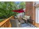 Outdoor deck furnished with wicker seating and a red umbrella, perfect for entertaining guests at 5513 Doemont Dr, Apex, NC 27539