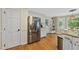 Spacious kitchen features stainless steel refrigerator, hardwood floors, and access to the eat-in breakfast nook at 5513 Doemont Dr, Apex, NC 27539