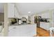 Bright kitchen featuring white cabinets, an island, granite countertops, stainless steel appliances, and hardwood floors at 5513 Doemont Dr, Apex, NC 27539