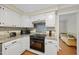 Modern kitchen with white cabinets, granite countertops, a black oven range, and hardwood floors at 5513 Doemont Dr, Apex, NC 27539
