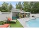 Inviting pool area with lounge chairs, an outdoor fireplace, and a covered patio, perfect for relaxation and entertainment at 5513 Doemont Dr, Apex, NC 27539