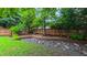 Beautiful backyard featuring a wooden fence, lush greenery, decorative gravel, and a charming bridge at 5535 Spindlewood Ct, Durham, NC 27703