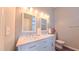 Bathroom featuring double vanity sinks with white cabinets and marble countertops at 5535 Spindlewood Ct, Durham, NC 27703