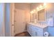 Bathroom with double vanity sinks, white cabinets, and modern lighting at 5535 Spindlewood Ct, Durham, NC 27703