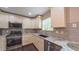 Modern kitchen with stainless steel appliances, granite countertops, and ample natural light at 5535 Spindlewood Ct, Durham, NC 27703
