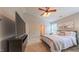 Well-lit main bedroom featuring carpet, ceiling fan, and a large TV at 5535 Spindlewood Ct, Durham, NC 27703