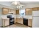 Well-lit kitchen with wood cabinets, updated appliances, and a double sink at 5849 Rocking Chair Dr, Youngsville, NC 27596