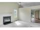 Bright living room with a cozy fireplace, ceiling fan, and an open doorway, creating a warm atmosphere at 5849 Rocking Chair Dr, Youngsville, NC 27596