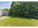 View of the backyard with green grass and mature trees at 5940 Brambleton Ave, Raleigh, NC 27610